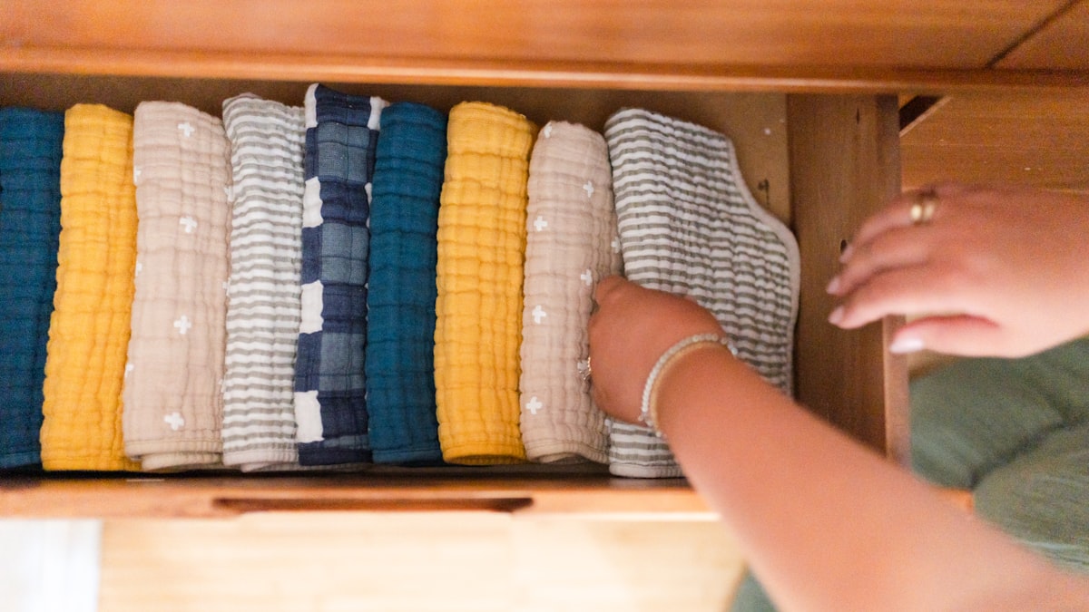 Folded baby clothes in a nursery drawer
