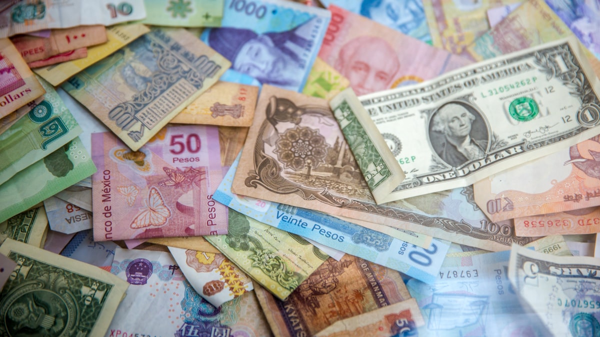 Calculator and currency notes representing international money transfer costs