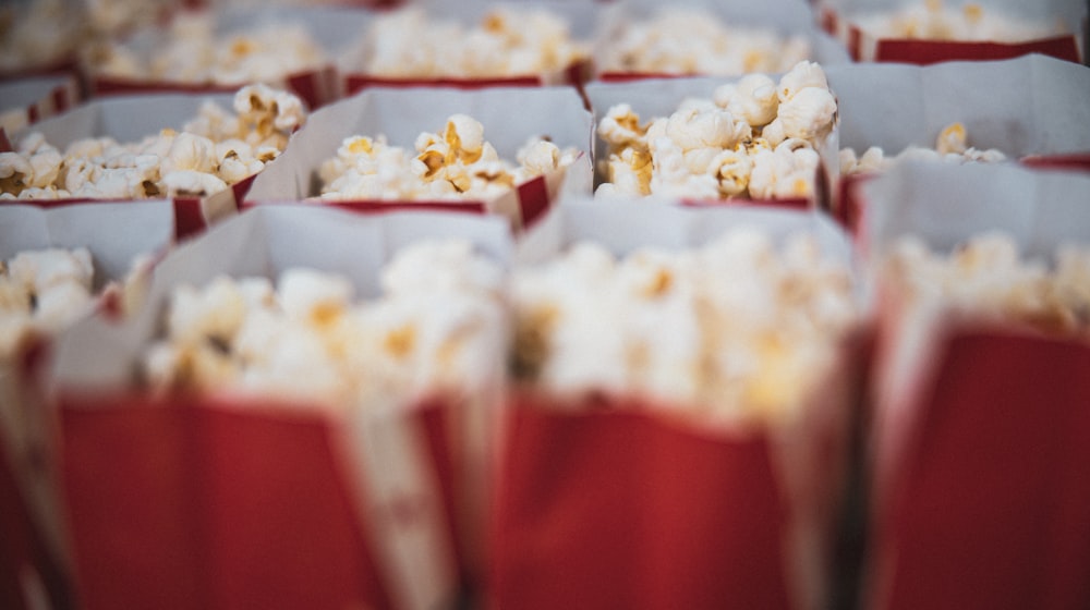 A bowl of popcorn and remote control set up for movie night